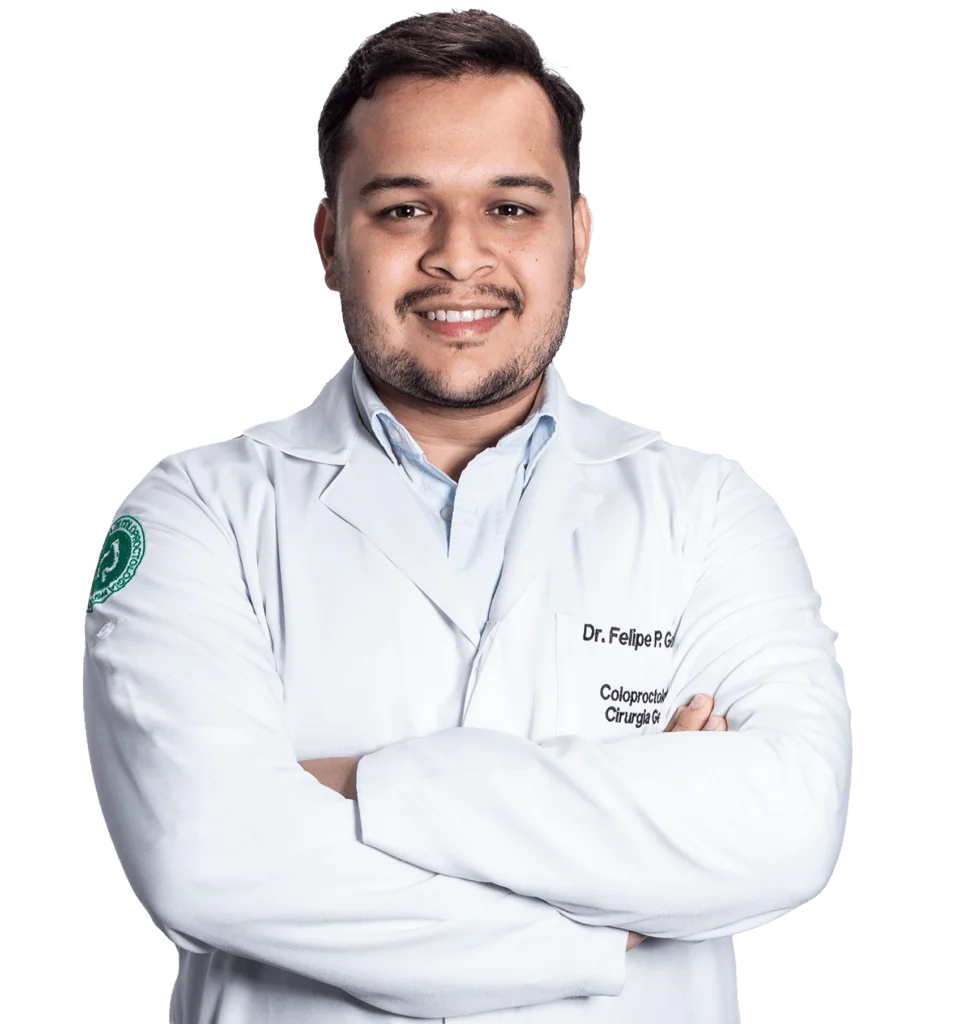 Dr. Felipe Pereira Gomes, médico coloproctologista em Blumenau e Indaial, de jaleco branco com o brasão da Sociedade Brasileira de Coloproctologia